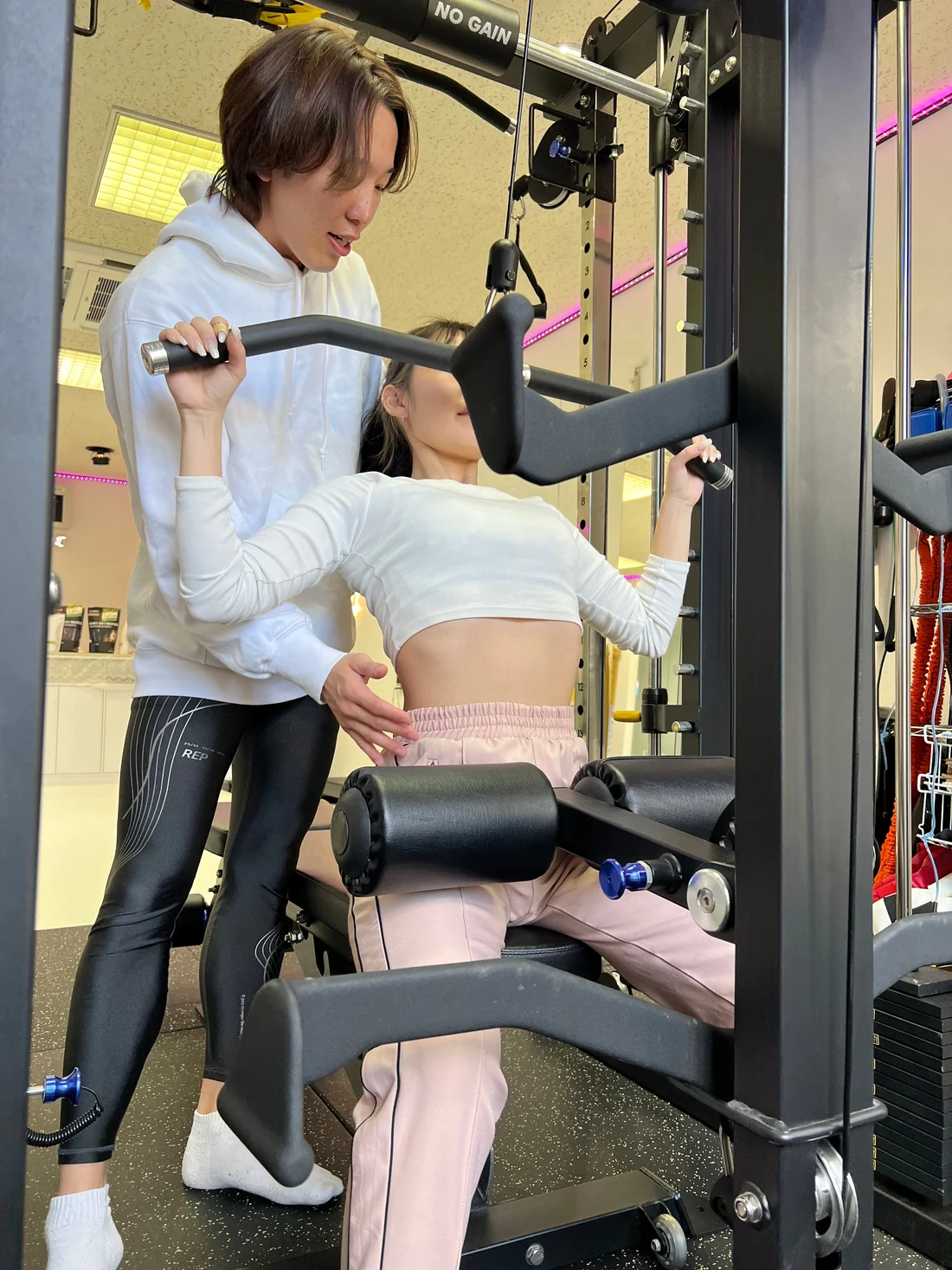 PTBπでトレーナーのサポートを受けながらトレーニングする女性